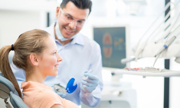 Dentist Giving Invisalign Aligners to Young Woman
