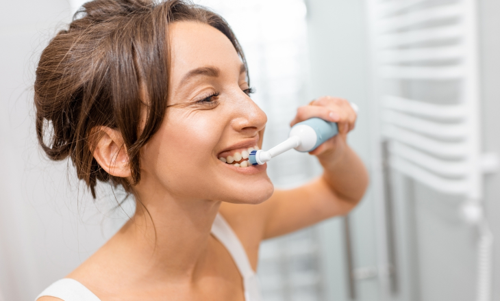 Woman Brushing Teeth with Electric Toothbrush
