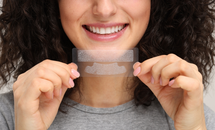 Smiling Woman Holding Whitening Strip